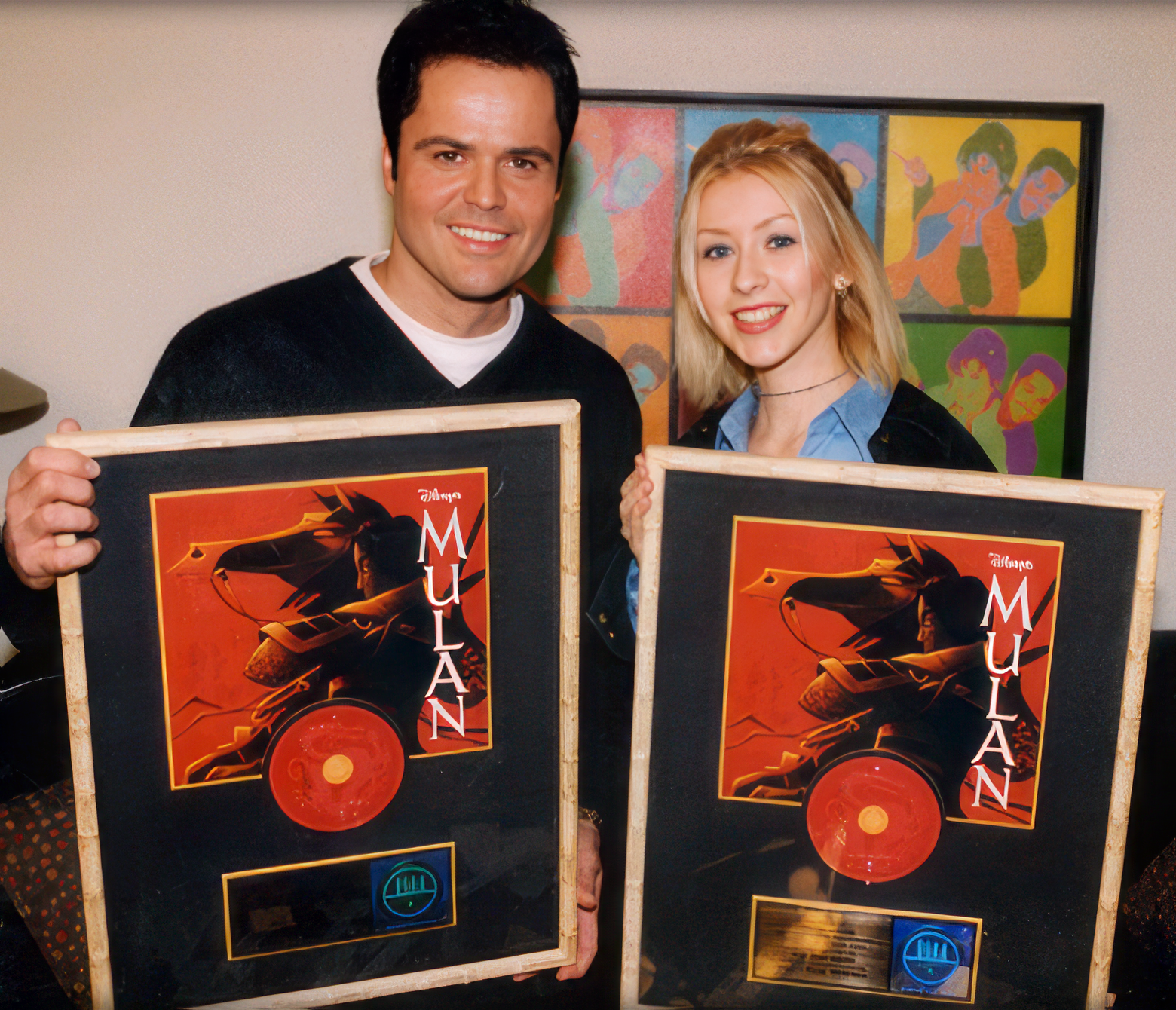 Donny Osmond and Christina holding gold records for "Mulan"
