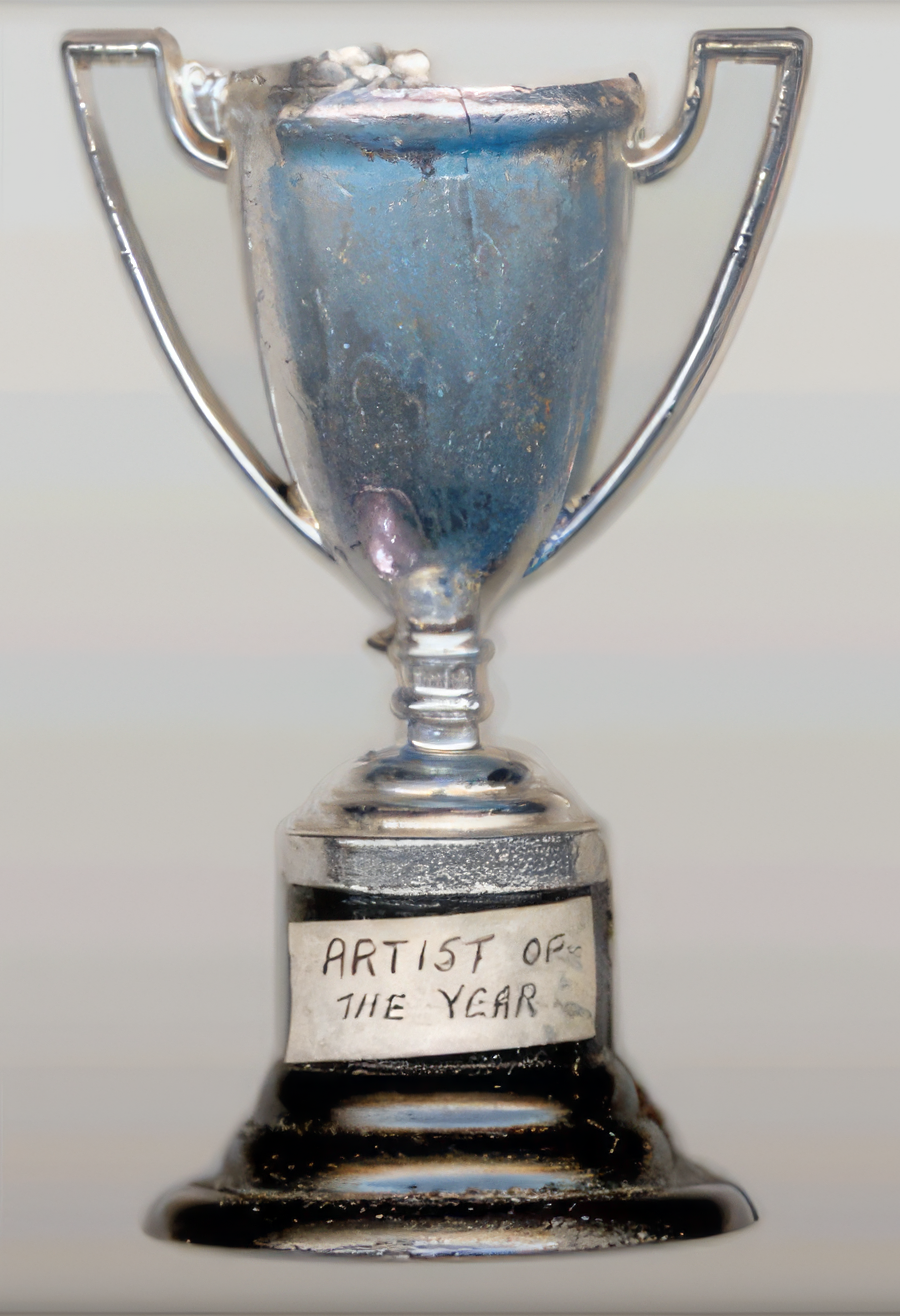 A small, homemade trophy, proclaiming Christina "Artist of the Year"
