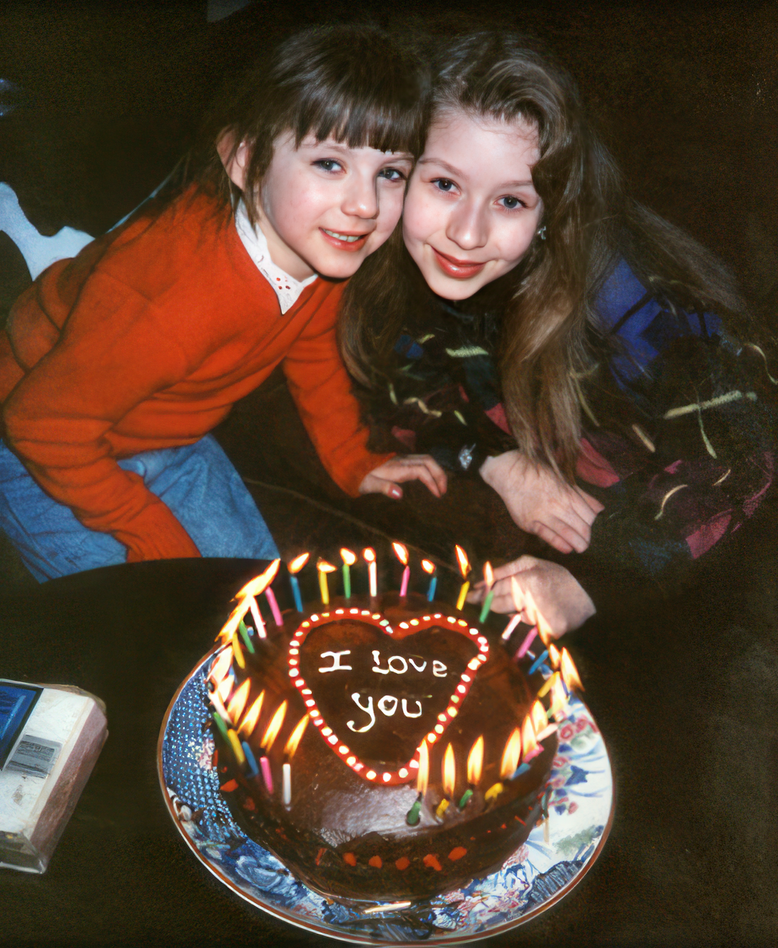 Christina, age 10, and Rachel, age 5, celebrating a birthday with a homemade cake.
